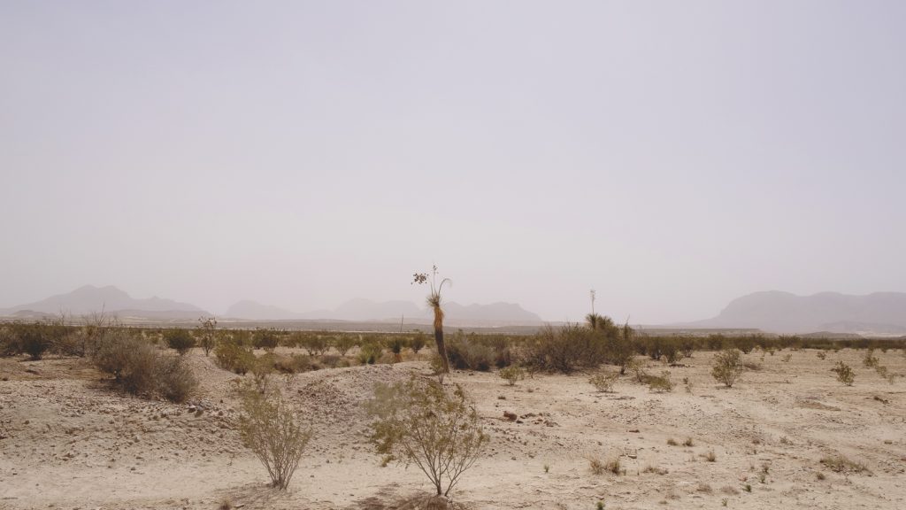 Hazy creamy desert view with mountains far off