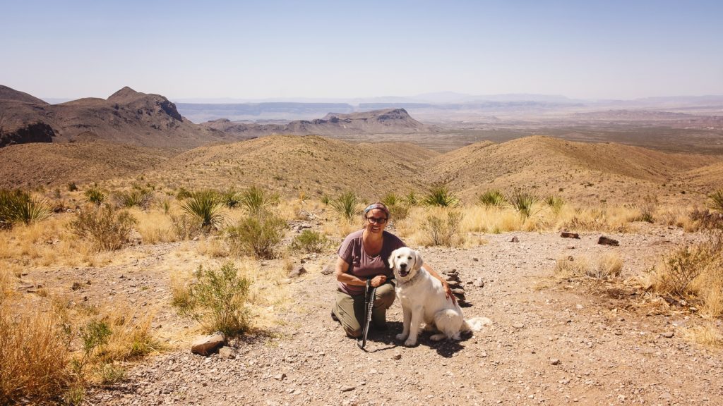 Photo of woman (me) and dog on a path at the top of an overlook with the mountains and valley stretching below to the horizon