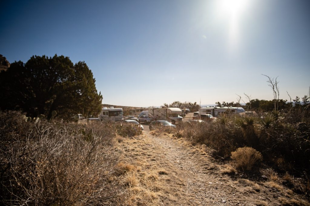 Path down the hill looking at a crowded parking lot with campers