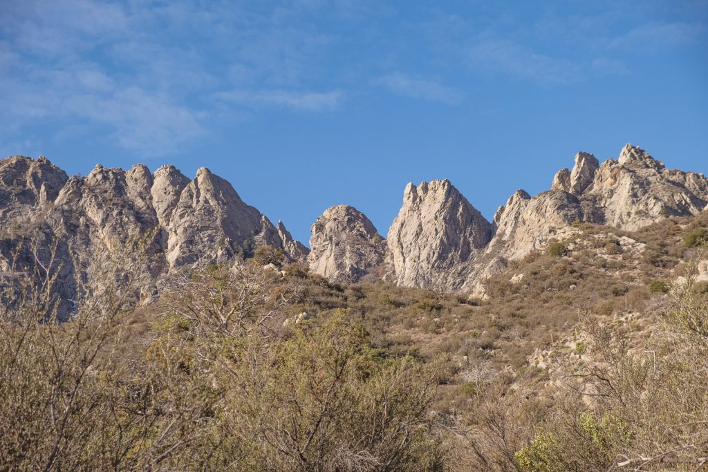 Jagged mountains rising like organs with blue sky above