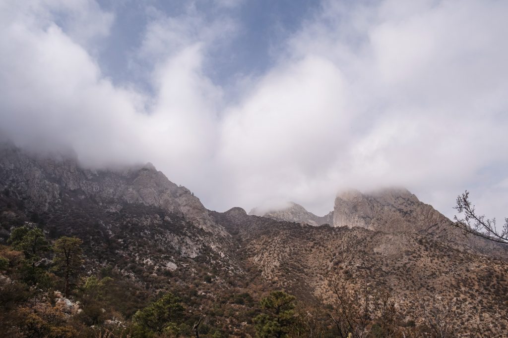 Jagged mountains towering above, with tops in the clouds